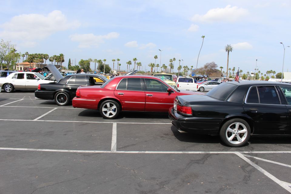 Black, red and white full-size sedans parked at angles in a car-show lot