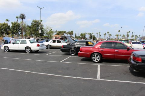 White, black and red full-size sedans lined up at an outdoor car show
