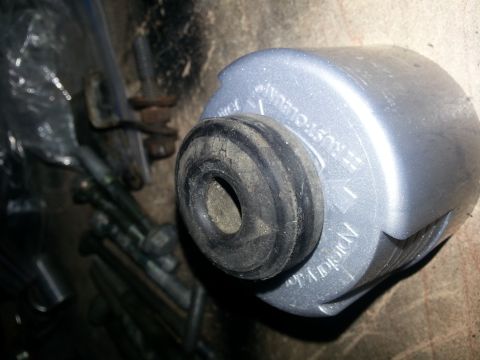 1994 Ford Bronco - A silver automotive part with a black rubber seal is shown, embossed text on its casing.