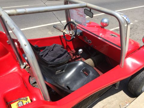 1968 Ford Mustang - A red dune buggy with a roll cage and black bucket seat is parked on the street.