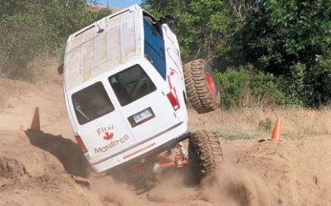 1990 Ford Bronco - This modified van is attempting an off-road course, with one side lifted high off the ground.
