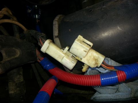 1994 Ford Bronco - Close-up of engine wiring harness connectors and tubing.