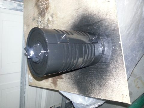 1994 Ford Bronco - Cylindrical part with fins, painted black, resting on a surface with overspray.