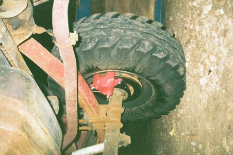 1979 Ford Bronco - Close-up of the rear wheel assembly on a 1979 Ford Bronco, showing the tire, brake caliper, and suspension.