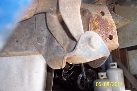 1978 Ford Bronco - View of vehicle undercarriage components with a motorcycle and propane tanks visible in the background.