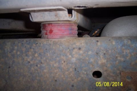 1978 Ford Bronco - Red suspension bushing visible on a heavily rusted vehicle frame.
