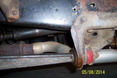 1978 Ford Bronco - The underside of a vehicle displays a rusty exhaust system and suspension components.