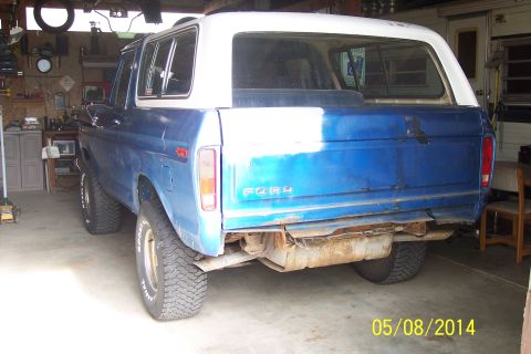 1978 Ford Bronco - This 1978 Ford Bronco is seen from the rear in a garage setting, showing its blue body and white top.
