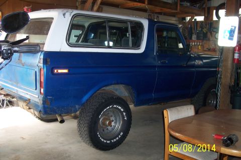 1978 Ford Bronco - Side view of a blue and white 1978 Ford Bronco in a garage setting.