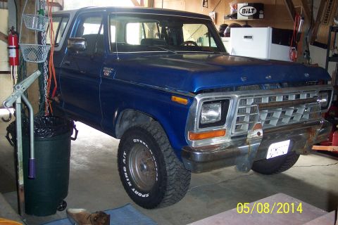 1978 Ford Bronco - A blue 1978 Ford Bronco is parked in a garage, viewed from the front three-quarter angle.