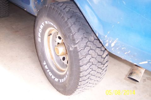 1978 Ford Bronco - Close-up of a blue vehicle's rear wheel, showing the tire and exhaust pipe. The registry claims it is a 1978 Ford Bronco, but this is not v…