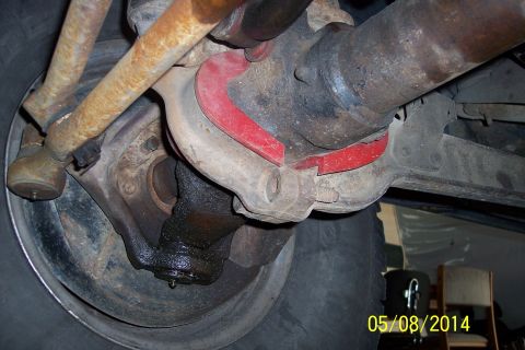 1978 Ford Bronco - Underside view of suspension parts, showing tie rods and red bushings. No vehicle is visible.