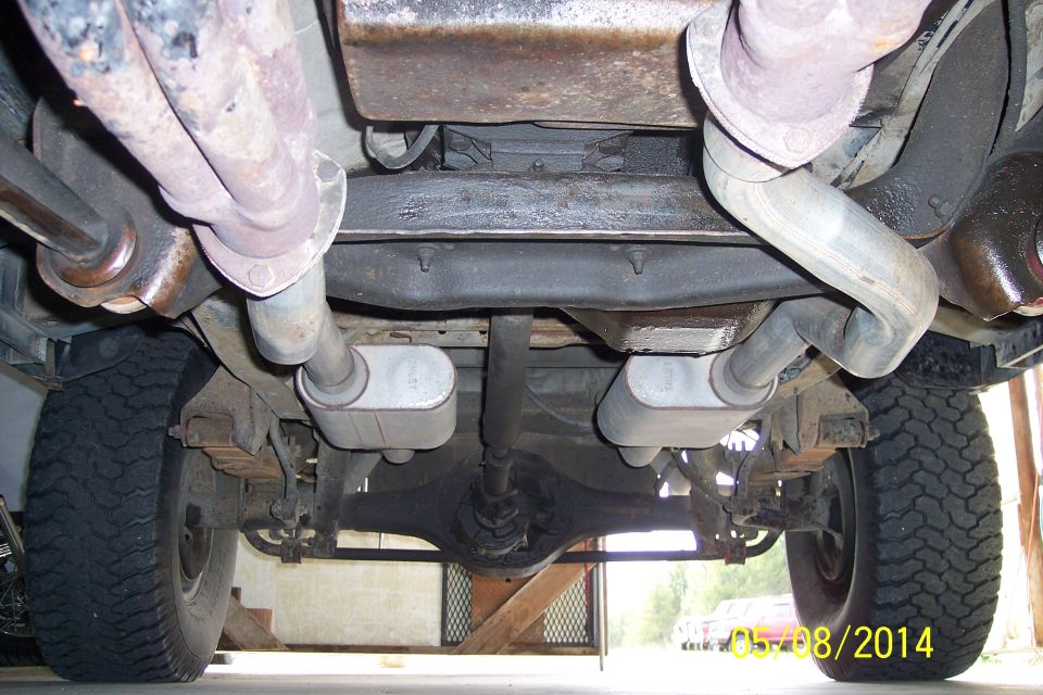 Undercarriage of a vehicle showing dual exhaust pipes, leaf springs, and a differential