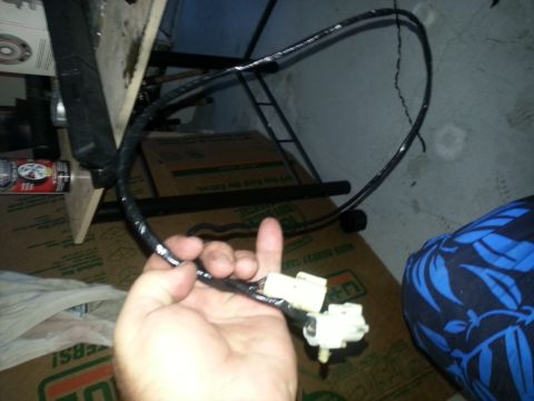 1994 Ford Bronco - Close-up of automotive battery cables with white connectors held in a hand.