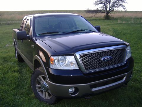 2007 Ford F-150 - A dark blue Ford F-150 pickup truck is shown from a three-quarter front angle, parked outdoors on a sunny day.
