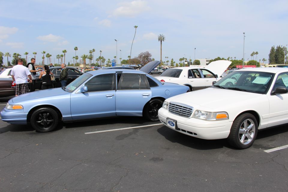 Light blue Ford sedan parked nose-to-nose with a white Ford sedan
