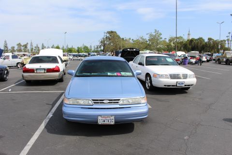 Front view of a light blue Ford sedan with a personalized 1SWTVIC plate