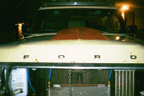 1979 Ford Bronco - The hood of a Ford truck shows the letters F-O-R-D and a prominent red hood scoop.