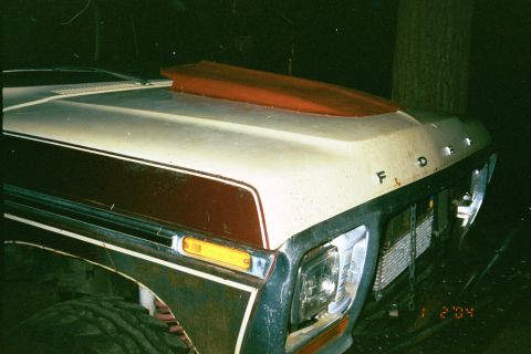 1979 Ford Bronco - Front view of a 1979 Ford Bronco showing its hood with a red scoop and distinctive body lines.