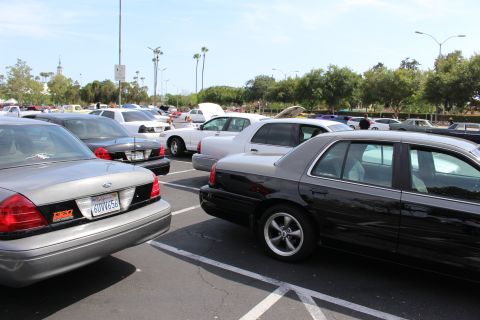 Silver and black full-size sedans parked at angles in a lot, black car on machined-spoke wheels