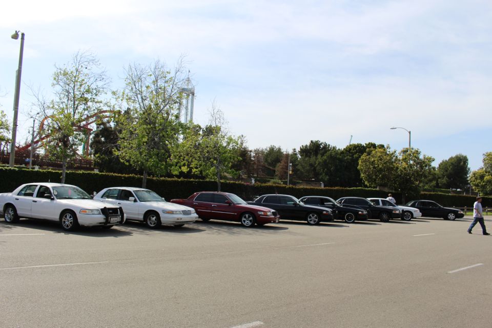 Lineup of parked sedans as a person walks across the empty lot