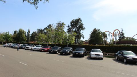 Sedans parked in a row with a person standing in the lot