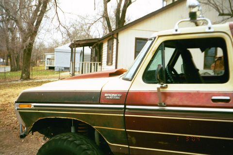 1979 Ford Bronco - This 1979 Ford Bronco features a prominent hood scoop and is parked in front of a residential building.