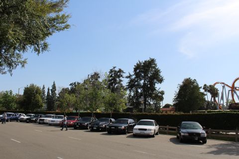 Row of parked sedans with a person crossing the lot