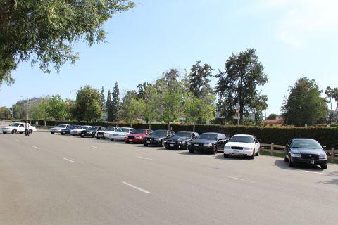 Row of sedans parked along a lot with a person walking
