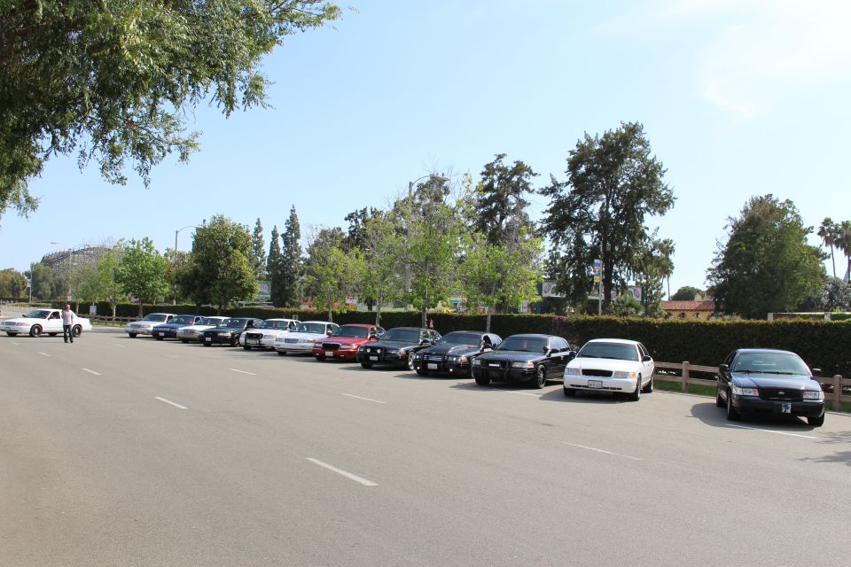 Row of sedans parked along a lot with a person walking