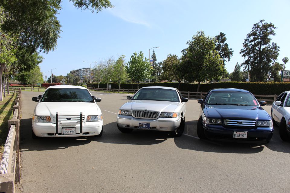Front view of three full-size sedans parked side by side, white, silver and dark blue