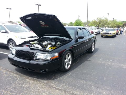 2003 Mercury Marauder - A black sedan is parked with its hood open, revealing the engine bay. Another vehicle is visible in the background.