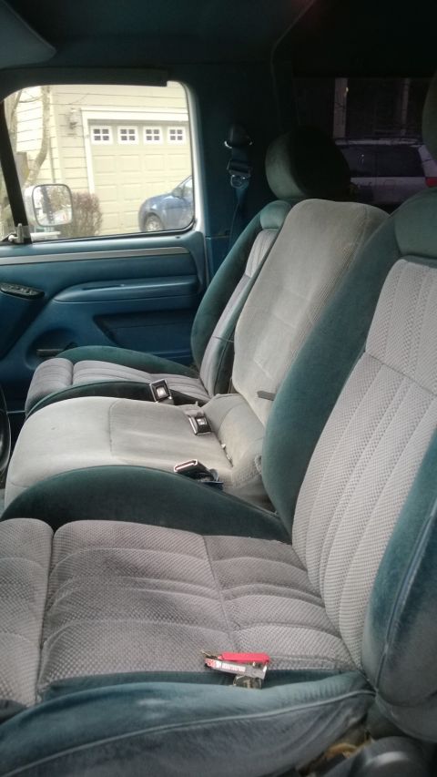 1994 Ford Bronco - The interior of a 1994 Ford Bronco features blue and gray cloth seats with visible seatbelts.