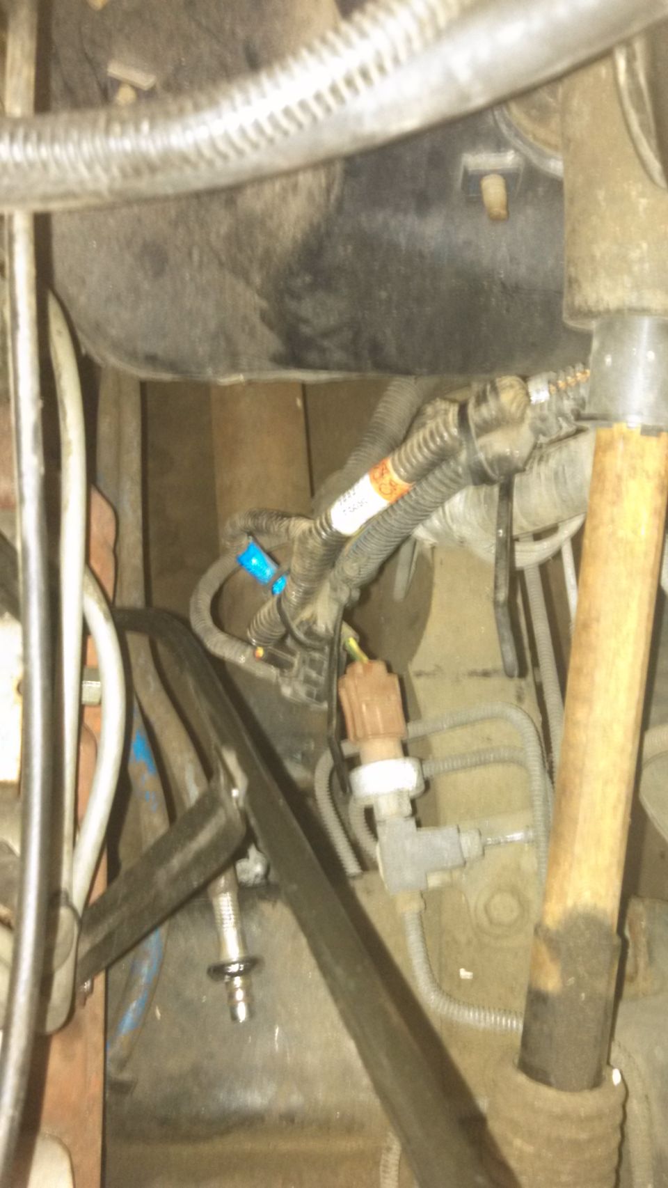 engine bay with wiring harness, sensors, and hoses visible