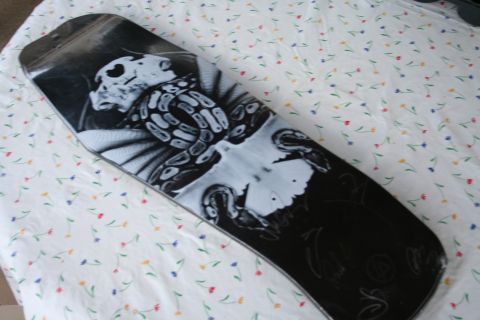 1997 Ford Probe - This skateboard features a detailed graphic of a skull and snake, resting on a patterned cloth.