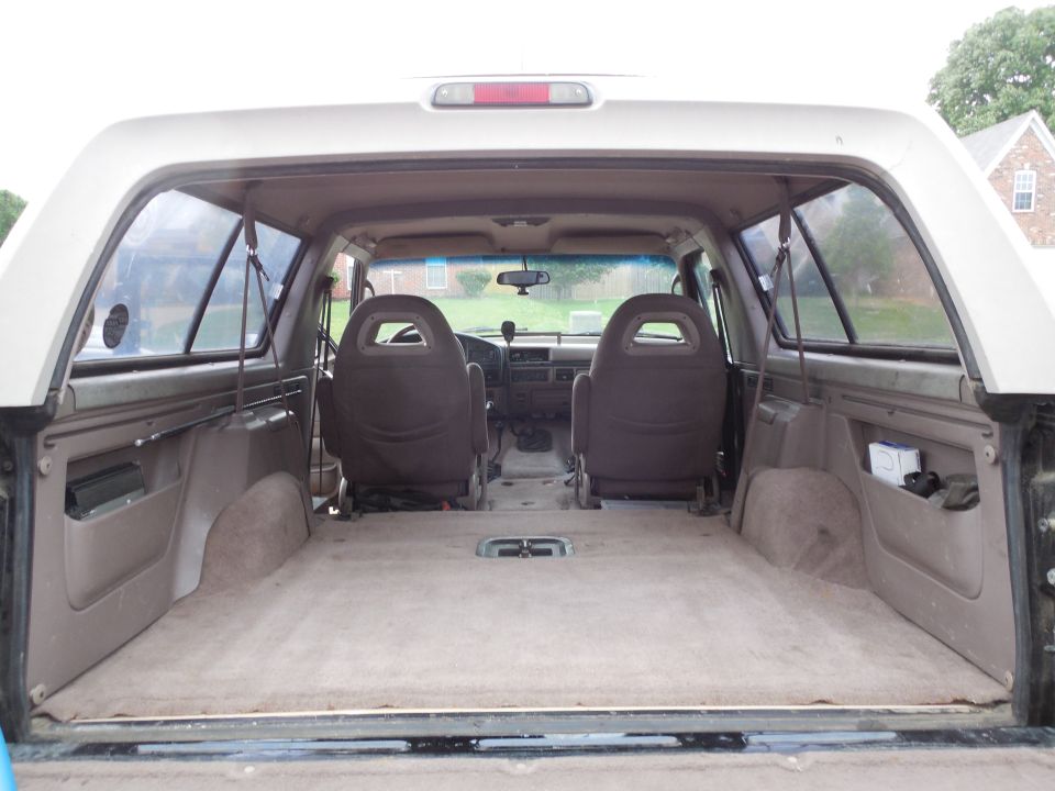 Rear cargo view of Bronco interior with tan carpet and two front seats facing dashboard