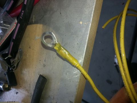 1994 Ford Bronco - A close-up shows a battery cable terminal and other wiring components on a workbench.