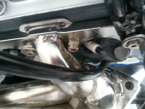 1994 Ford Bronco - Close-up view of an engine's spark plug and exhaust manifold.