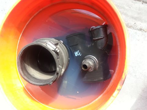 1994 Ford Bronco - Engine intake components submerged in a bucket, possibly for cleaning or maintenance.