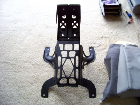1999 Mercury Grand Marquis - A black metal bracket, likely a car part, is shown on a carpeted floor with some fabric and tools nearby.