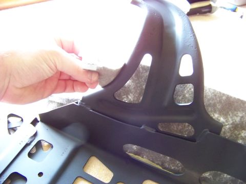 1999 Mercury Grand Marquis - A hand is shown cleaning or attaching a pad to a black metal car seat frame part.