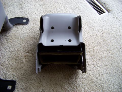 1999 Mercury Grand Marquis - A gray plastic interior car part, possibly a seat bracket, is shown on a carpeted surface.