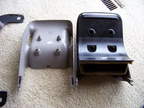 1999 Mercury Grand Marquis - Two disassembled car interior trim pieces are laid out on a carpeted floor.