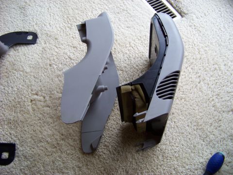 1999 Mercury Grand Marquis - Two disassembled car interior trim pieces are laid out on a carpeted surface.