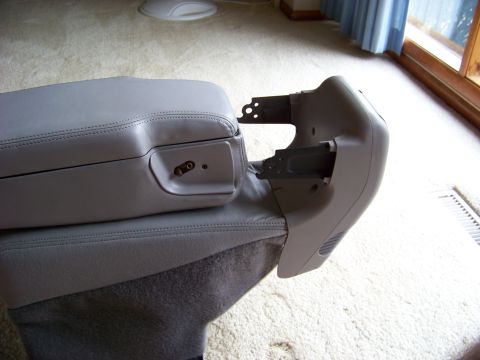 1999 Mercury Grand Marquis - A gray center console armrest is shown with its mounting hardware detached.