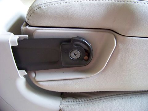 1999 Mercury Grand Marquis - A close-up view of a car's interior seat bracket mechanism, showing a screw securing the part.