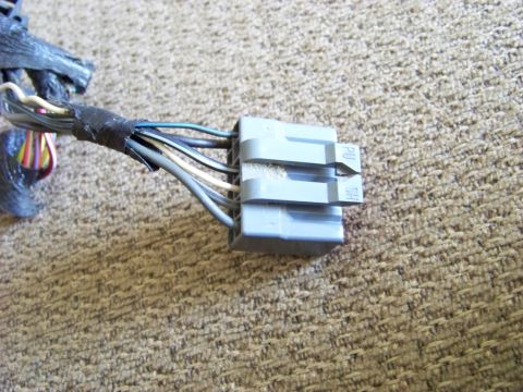 1999 Mercury Grand Marquis - A close-up shot shows a gray electrical connector with multiple wires, likely from a vehicle's wiring harness.