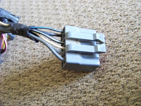 1999 Mercury Grand Marquis - A close-up of a vehicle's wiring harness connector, showing multiple wires and a gray plastic housing.