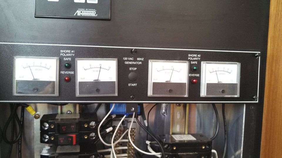 Boat electrical panel with four gauges, polarity indicators, and generator controls