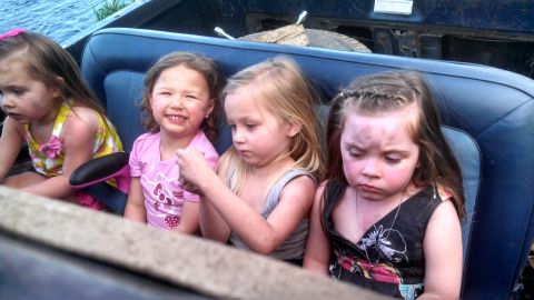 1979 Ford Bronco - Four young girls are seated in the back of a vehicle, appearing to have been playing outdoors.
